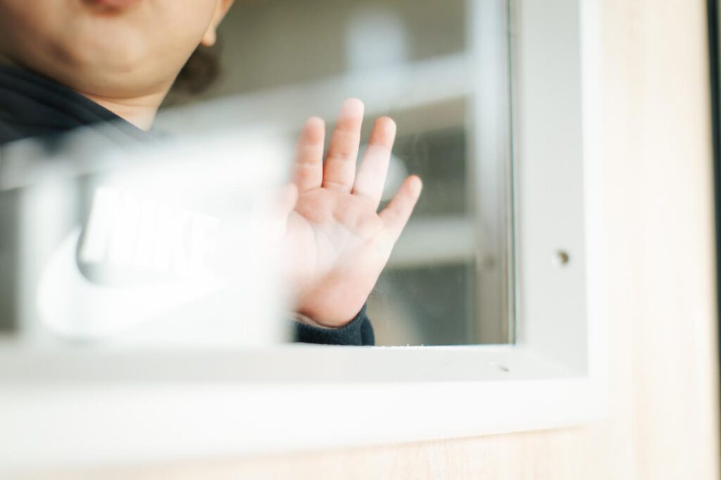 Enfant regardant par la fenêtre de sa micro-crèche