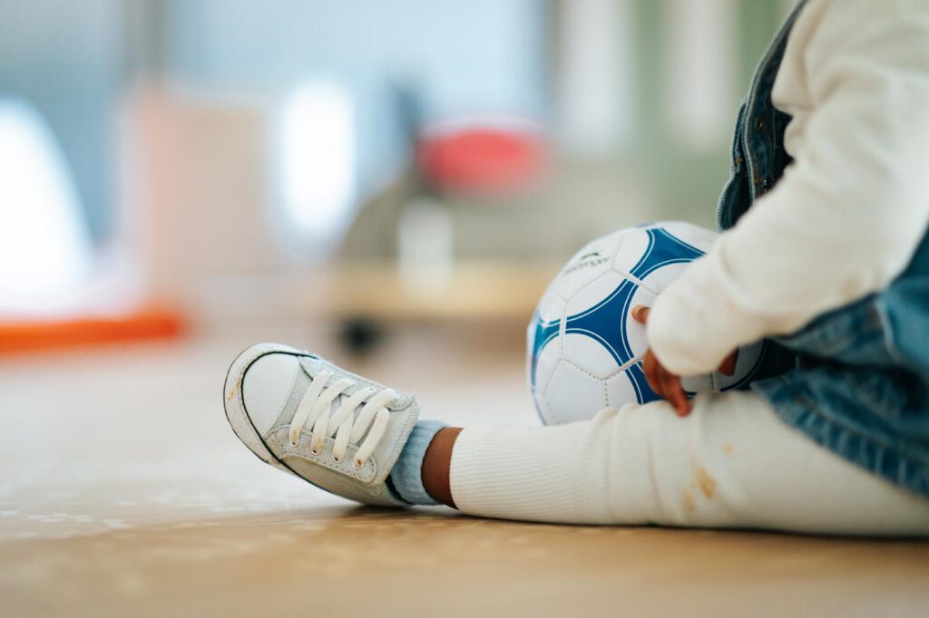 Enfant jouant au football dans une cour de récréation