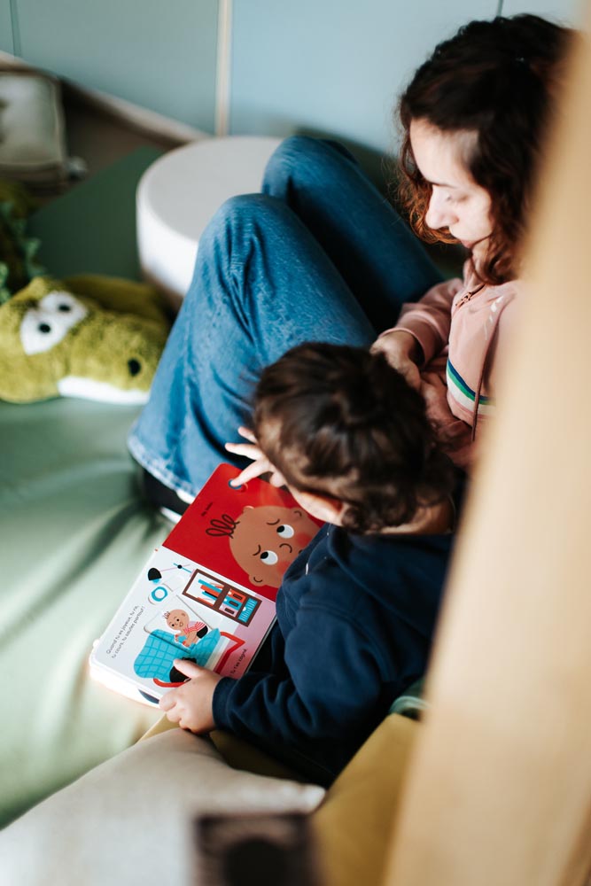 Enfant lisant un livre à sa nounou à la garderie